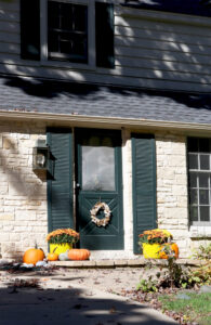 home decorated with fall decor on front porch